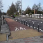 Grey city pole cones installed along a cycle lane to separate cyclists from vehicle traffic