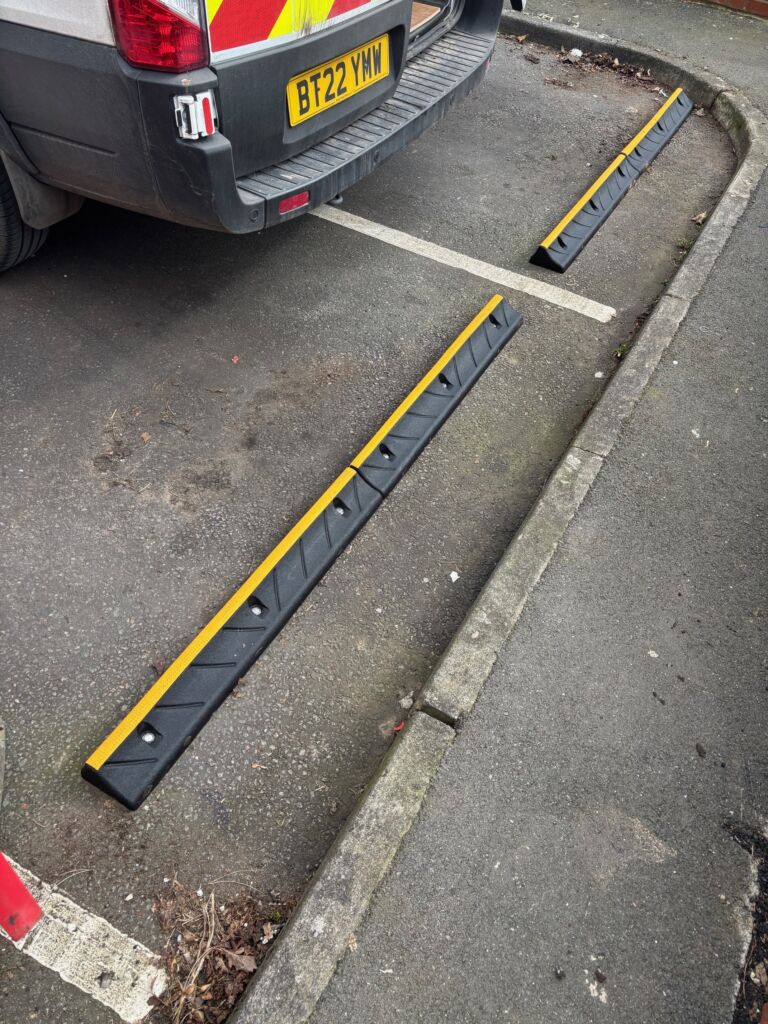 CarStop wheel stops installed across marked parking spaces in a car park.