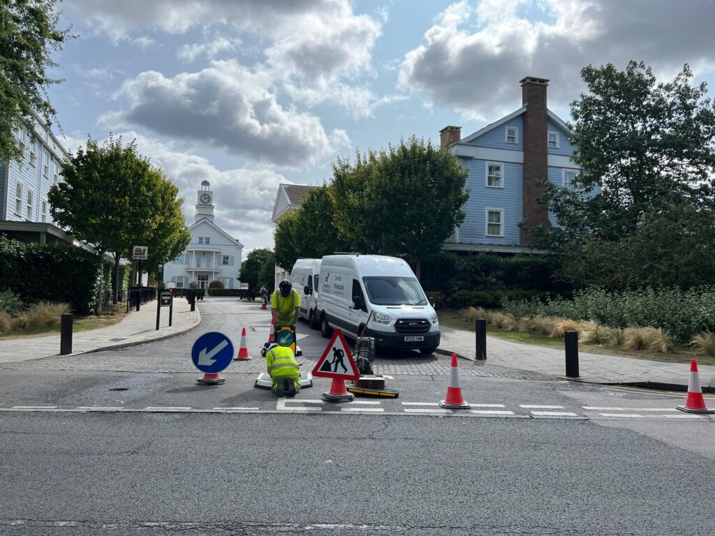 Installation team fitting traffic calming features with cones and temporary road signage in place.