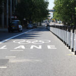 Black and white on-highway pole cones creating separation between a cycle lane and vehicle traffic
