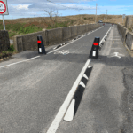 Kerb Orca units installed along a cycle lane on a bridge, providing physical separation between cyclists and vehicle traffic.