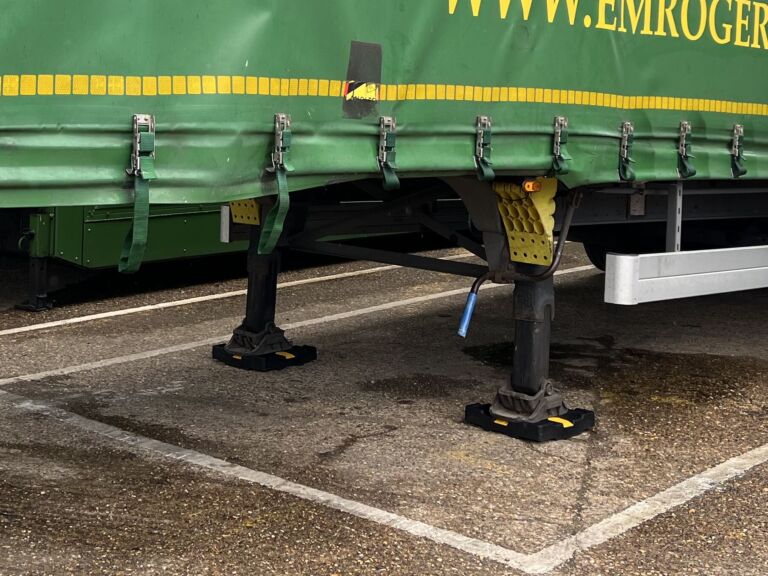 TrailerPad supporting the landing legs of a parked trailer.