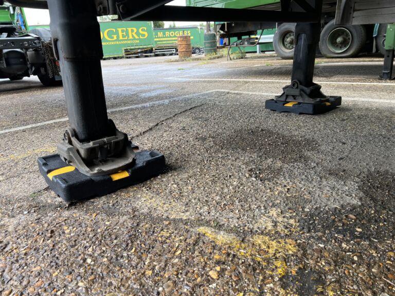 TrailerPad supporting the landing legs of a parked trailer.