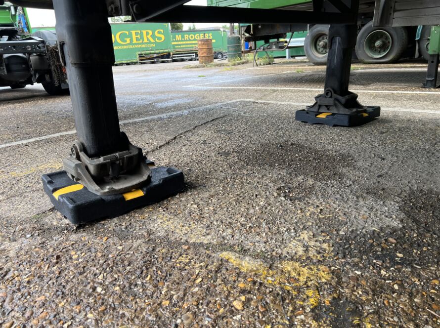 TrailerPad supporting the landing legs of a parked trailer.