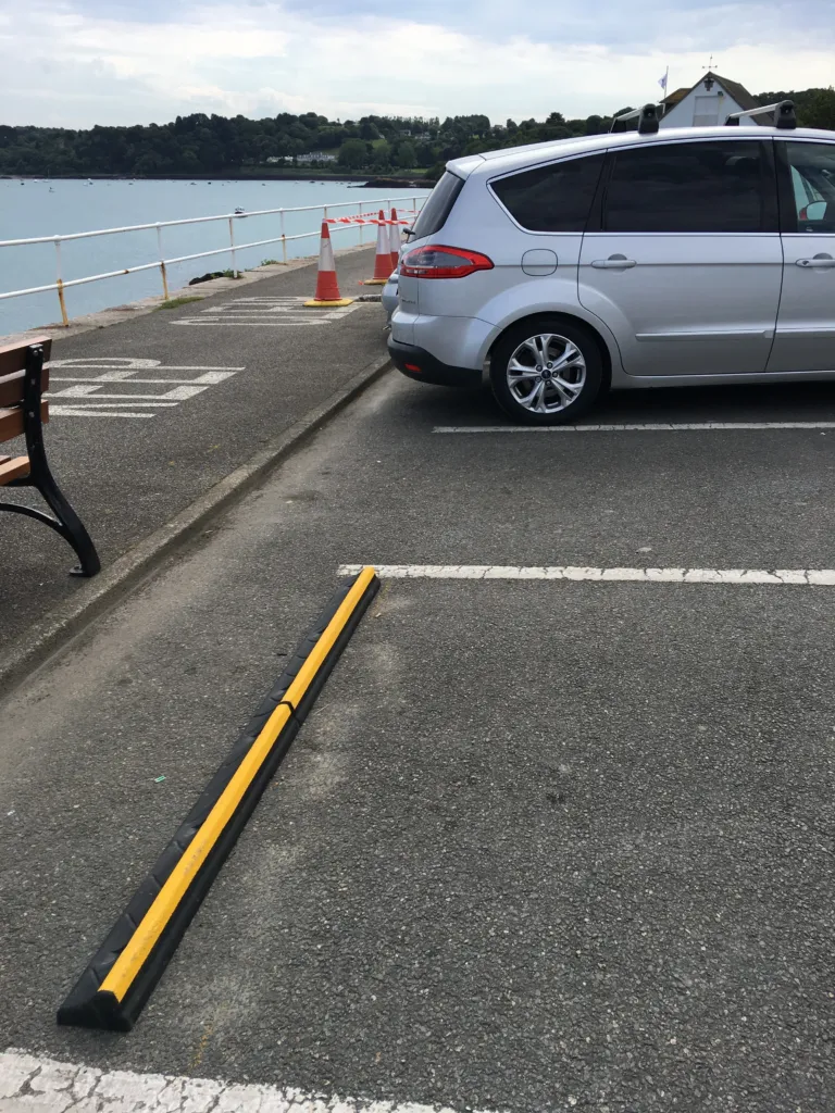 CarStop wheel stops installed across marked parking spaces in a car park.