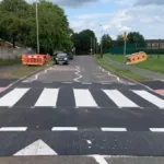 Completed pedestrian crossing featuring an installed combination table with zebra markings and tactile paving.