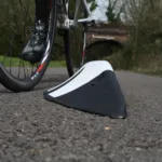 Close-up of an Orca zig-zag lane separator next to a cyclist’s wheel, illustrating the angled profile design.