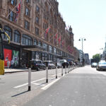 Black and white on-highway pole cones creating separation between a cycle lane and vehicle traffic