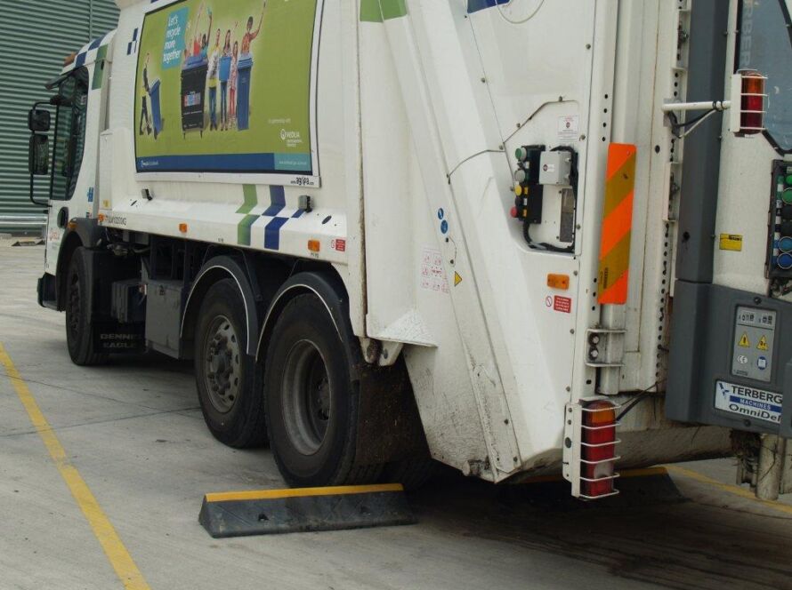 TruckStop 150 wheel stop positioned behind a lorry wheel to prevent vehicle movement.