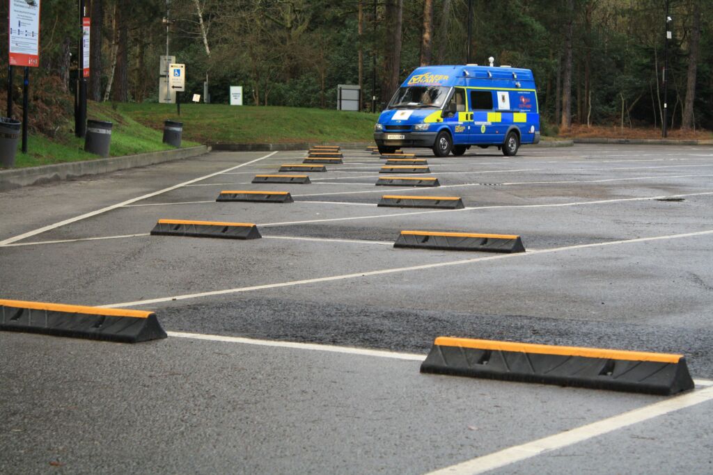 TruckStop 115 heavy-duty wheel stop with high-visibility yellow markings installed on a paved surface.