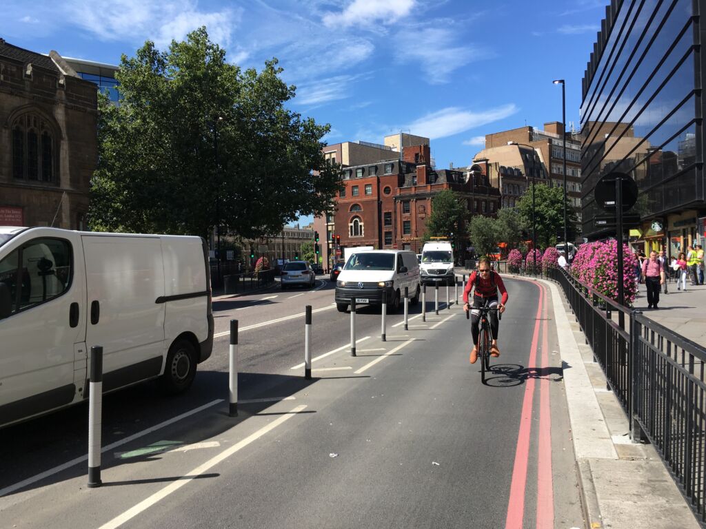 Black and white on-highway pole cones creating separation between a cycle lane and vehicle traffic