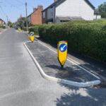 RediPave modular traffic island with moulded white edge markings and keep-left bollard installed on a residential road