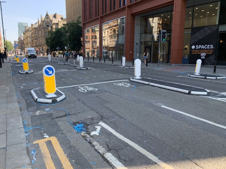 RediPave traffic islands with keep-left bollards and on-highway pole cones creating lane separation on an urban street.