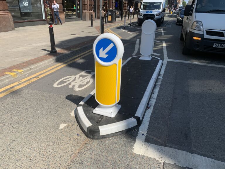 RediPave traffic island with keep-left bollard separating a cycle lane from traffic on an urban street.