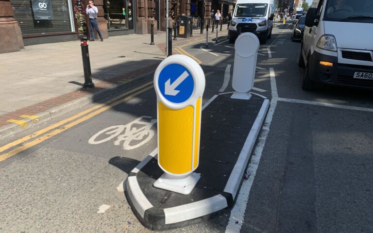 RediPave traffic island with keep-left bollard separating a cycle lane from traffic on an urban street.