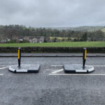 Two RediPave modular traffic islands with integrated white edge markings and bollards on a rural road.