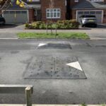 Traficop rubber speed cushions installed on a roadway featuring directional arrows for traffic calming.