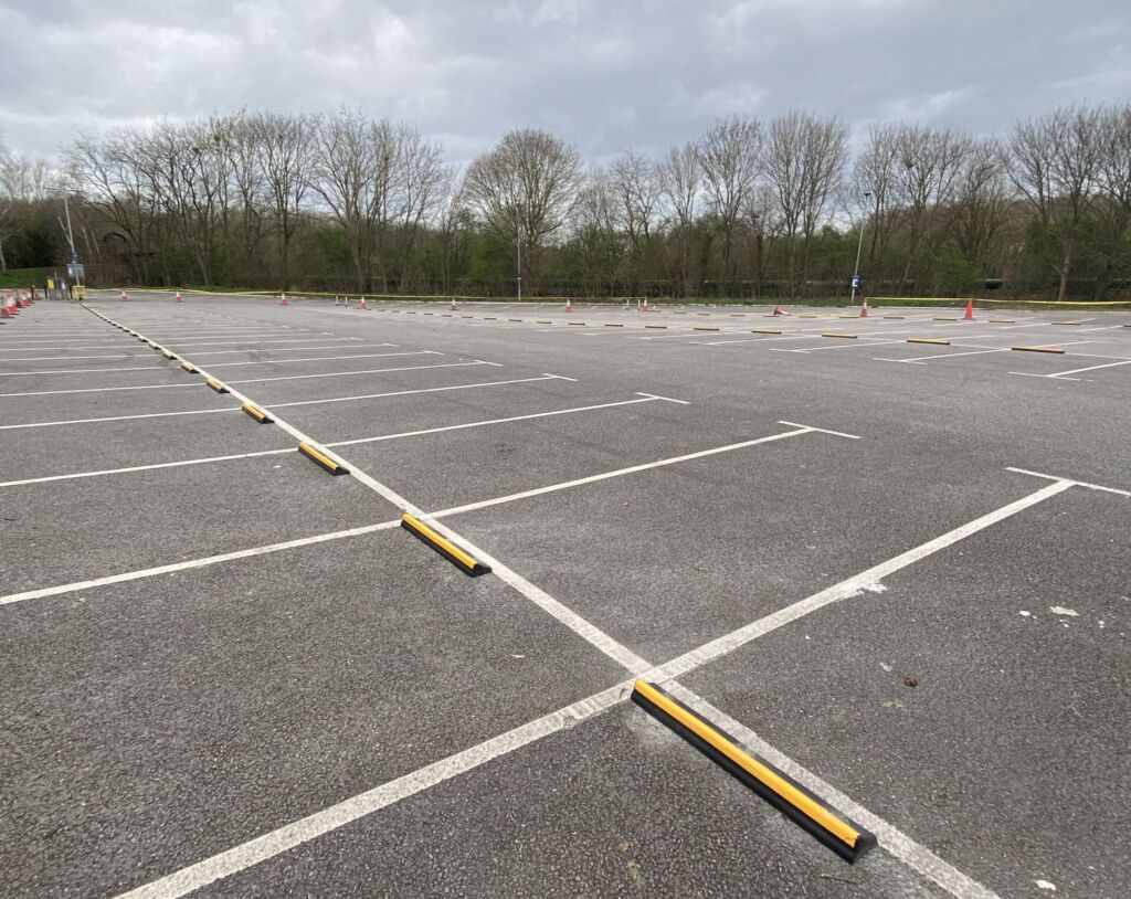 CarStop wheel stops with yellow reflective strip installed in a car park to define parking bays.
