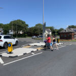 RediKerb half-battered (HB) modular kerbing forming a pedestrian refuge island with tactile paving at a road crossing on a roundabout approach.