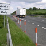 Orange and white on-highway pole cones installed to guide traffic along the highway