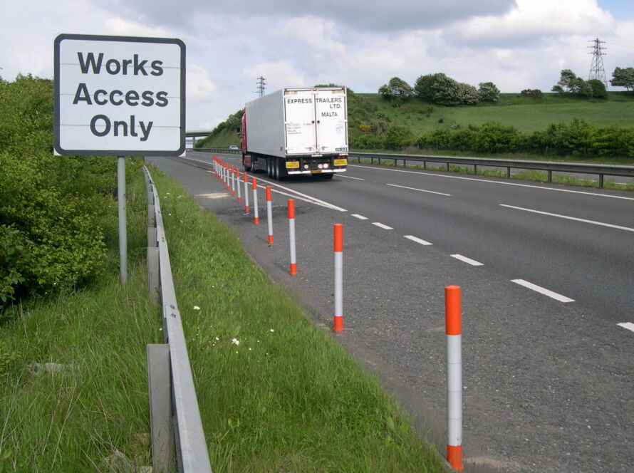 Orange and white on-highway pole cones installed to guide traffic along the highway