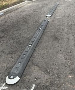 Milestone island installed on the carriageway with integrated glass reflectors.