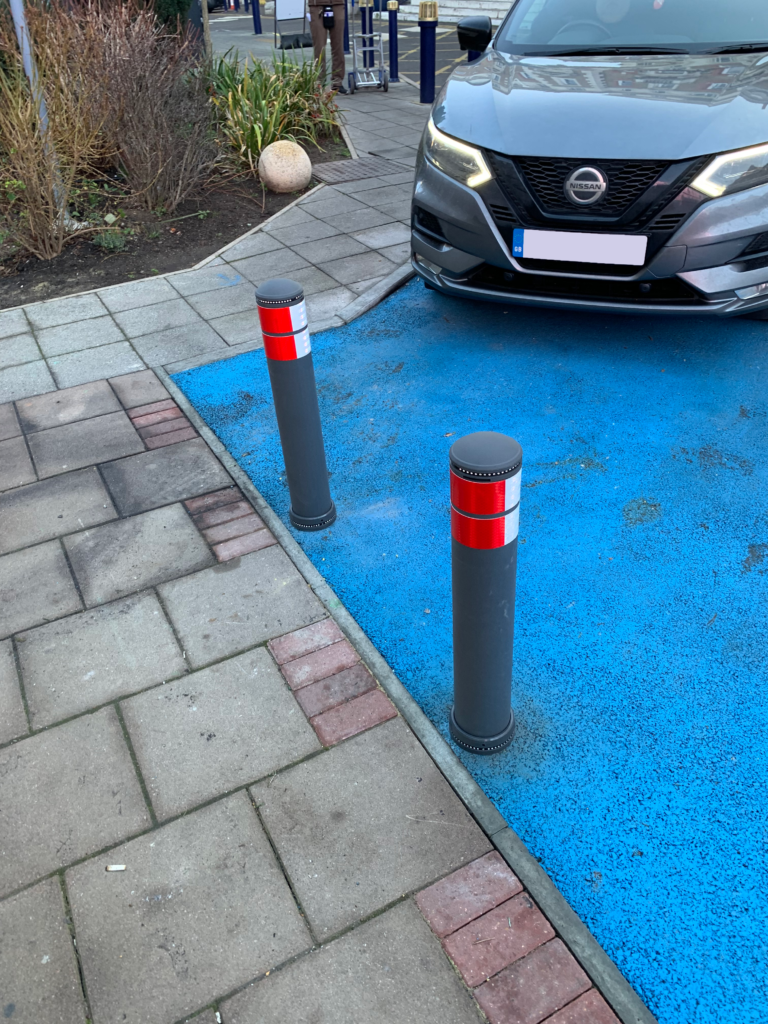 City pole cones installed at the edge of a marked parking bay to prevent vehicle overrun