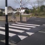 Raised rubber table with integrated zebra crossing installed in residential area, providing traffic calming and a level pedestrian crossing.