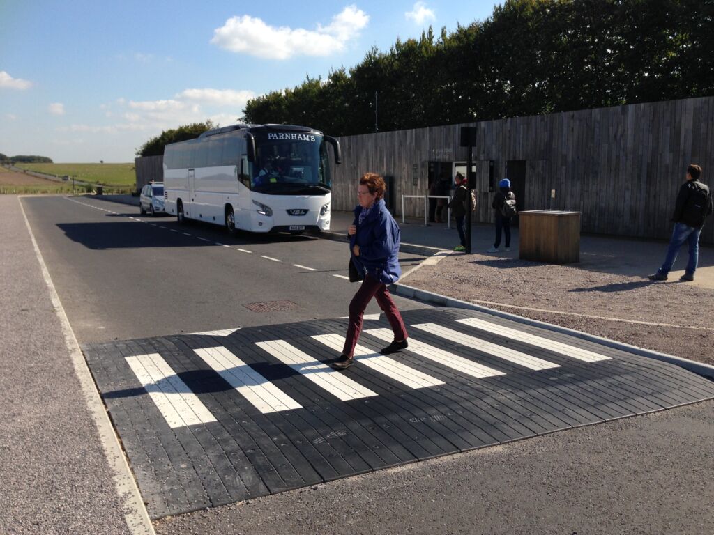 Raised rubber table with integrated zebra crossing installed in a car park access area, providing traffic calming and a level pedestrian crossing.