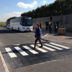 Raised rubber table with integrated zebra crossing installed in a car park access area, providing traffic calming and a level pedestrian crossing.
