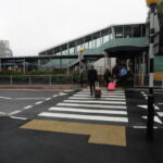 Raised rubber table with integrated zebra crossing installed at an airport access road, providing a level pedestrian crossing and traffic calming