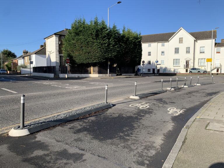 Series of satellite traffic islands with bollards separating a cycle lane from the carriageway