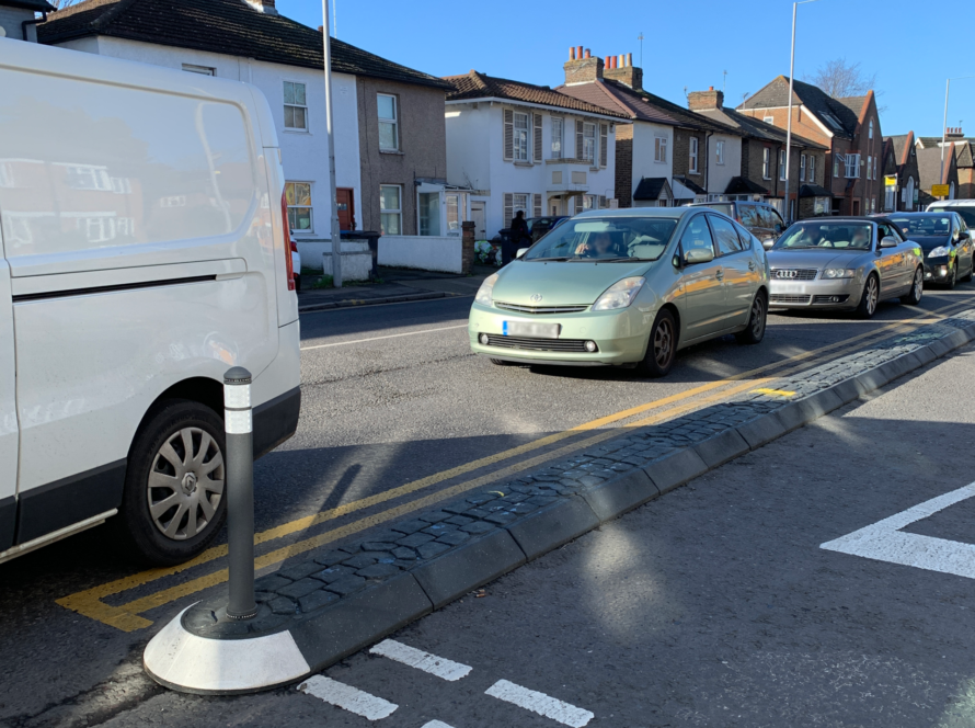 Satellite traffic island with bollard separating traffic lanes on a residential road