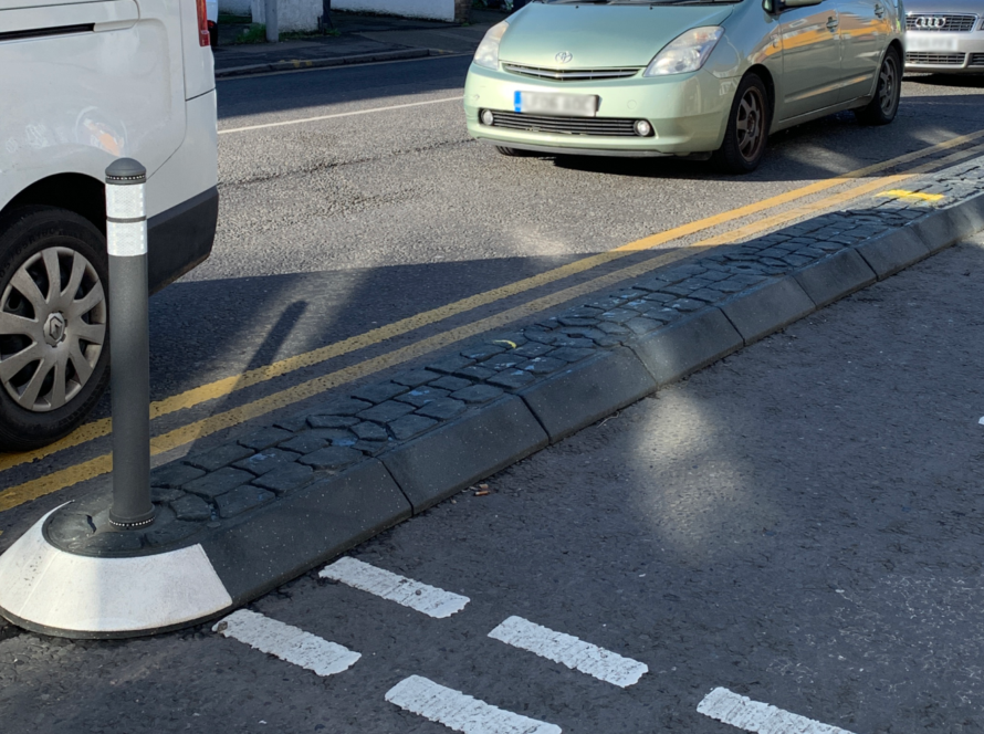 Satellite traffic island with bollard separating traffic lanes on a residential road
