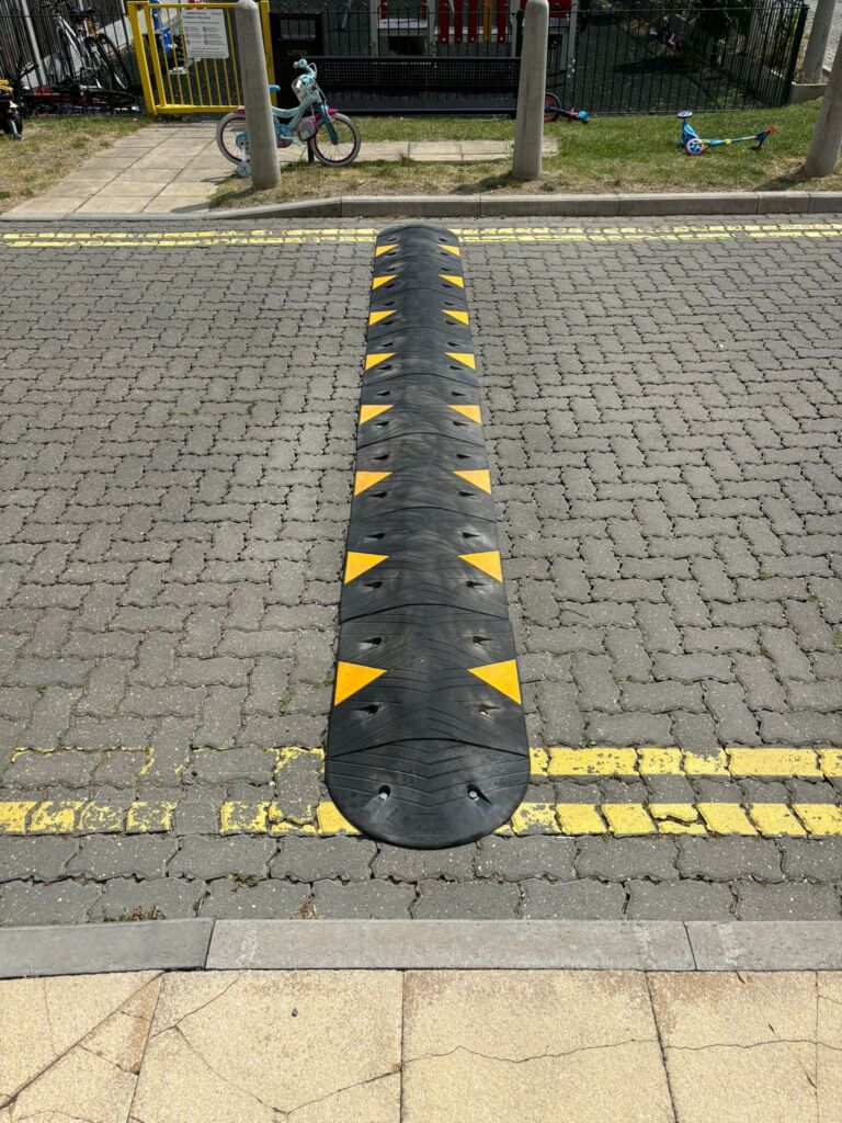 Sitecop modular speed ramp with high-visibility markings installed on a residential road for traffic calming.