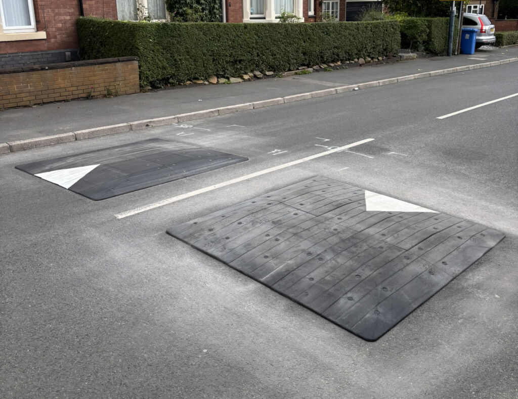 Traficop rubber speed cushions installed on a roadway featuring directional arrows for traffic calming.