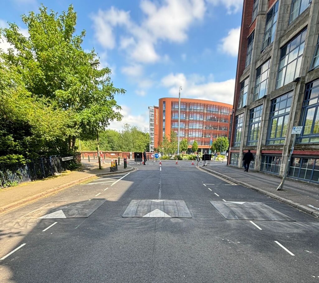 Traficop rubber speed cushions installed on a roadway featuring directional arrows for traffic calming.