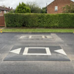 Traficop rubber speed cushions installed on a roadway, featuring white markings and directional arrows for traffic calming.