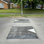 Traficop rubber speed cushions installed on a roadway featuring directional arrows for traffic calming.