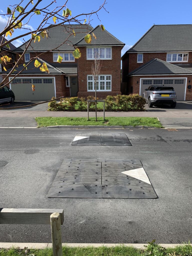 Traficop rubber speed cushions installed on a roadway featuring directional arrows for traffic calming.