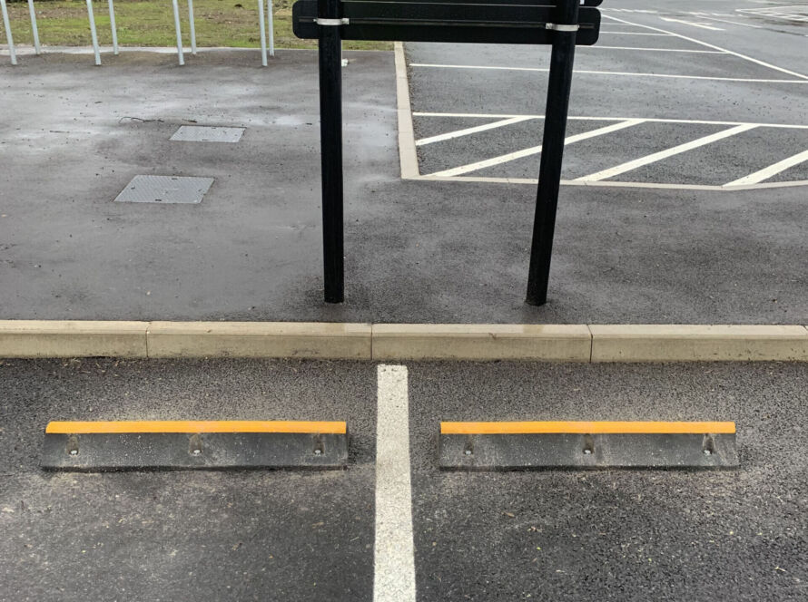 TruckStop 115 heavy-duty wheel stop with high-visibility markings installed to control vehicle stopping position.