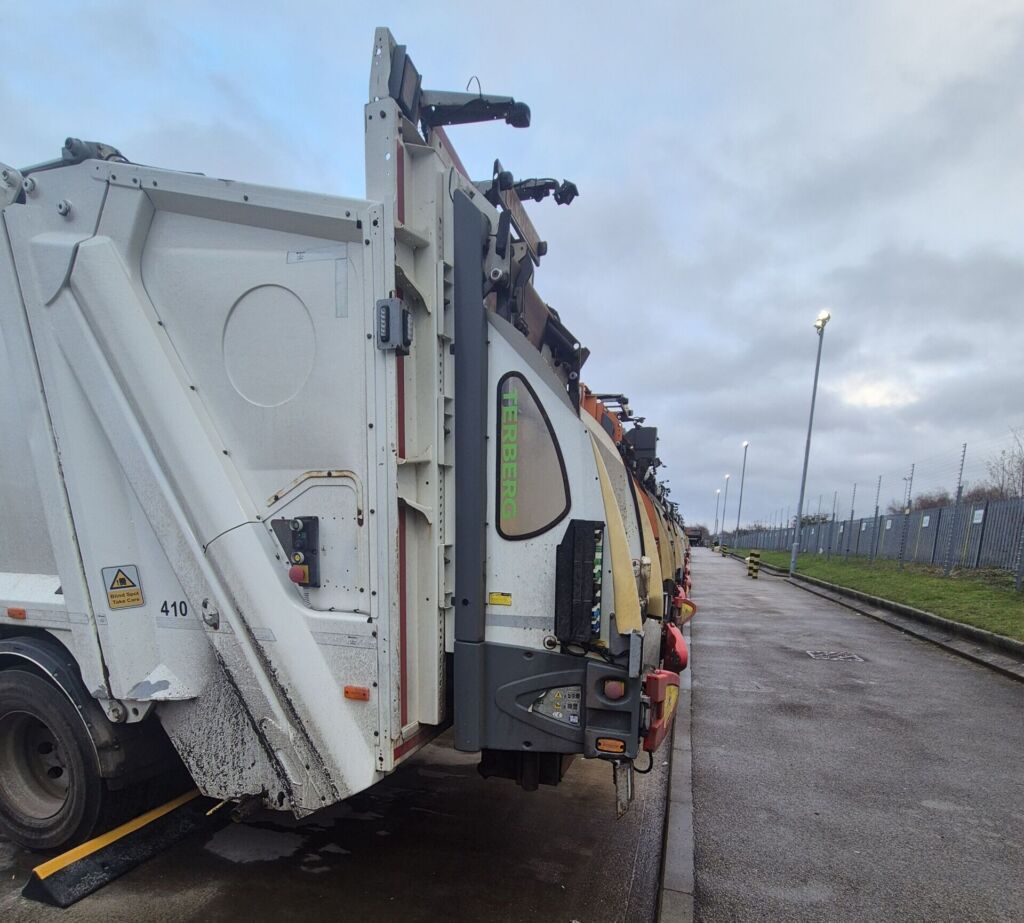 TruckStop 150 wheel stop positioned behind a lorry wheel to prevent vehicle movement.