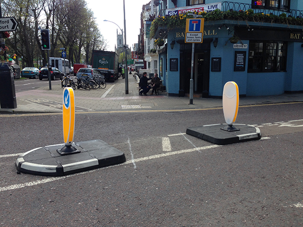Pair of RediPave traffic islands in black and white with bollards guiding traffic at junction.
