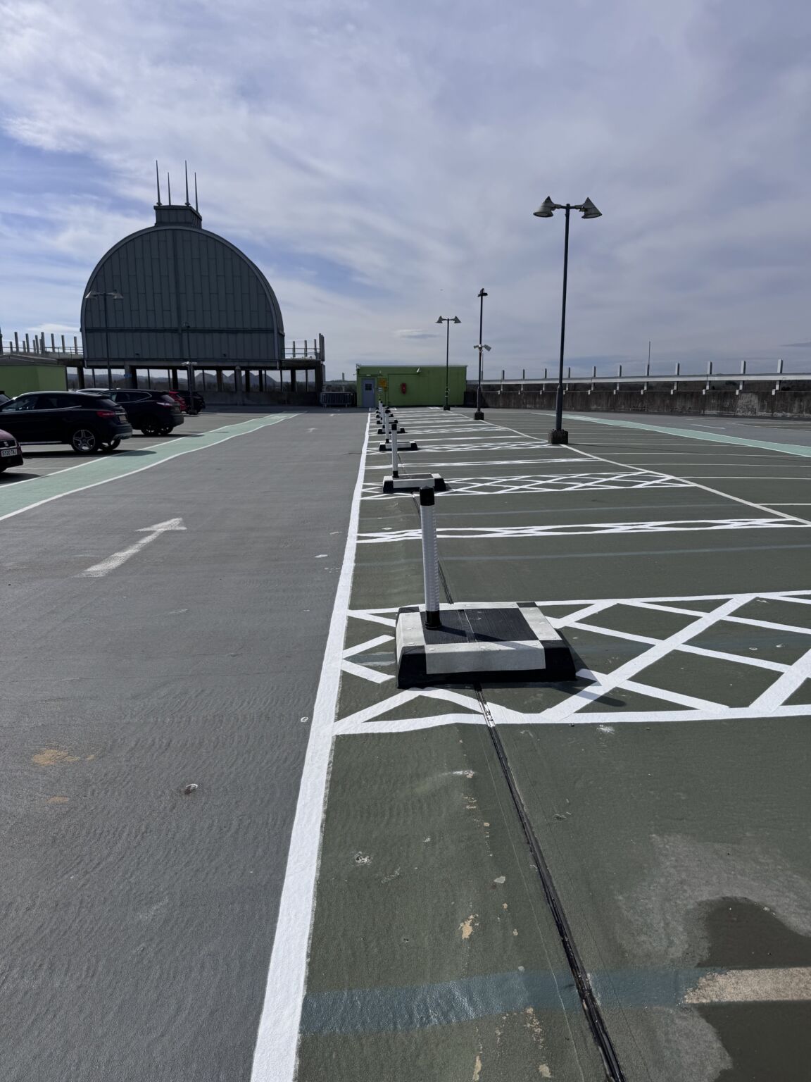 Black and white modular kerbing installed in rooftop car park to define bays and guide vehicle movement.