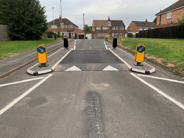 Newly installed speed table and traffic island system on a residential road.