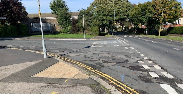 Junction corner prior to kerbing installation, showing open road layout and pedestrian crossing area.