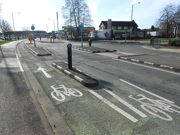 Black and white RediKerb installed alongside cycle lane, forming raised separator with bollard for traffic control.