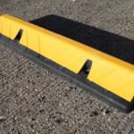 TruckStop 115 heavy-duty wheel stop with extended high-visibility markings installed to control vehicle stopping position.