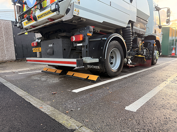TruckStop 115 heavy-duty wheel stop with extended high-visibility markings installed to control vehicle stopping position.